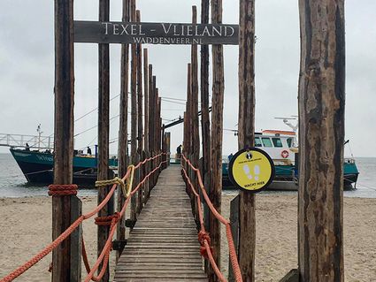 Via een houten brug op het strand bereik je de pont