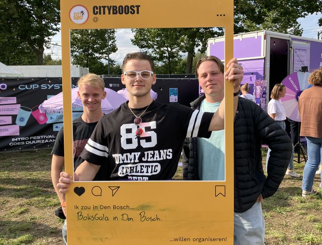 Foto van drie jongens die een grote fotolijst vasthouden met de tekst: Cityboost | Ik zou in Den Bosch... boksgala in Den Bosch... willen organiseren