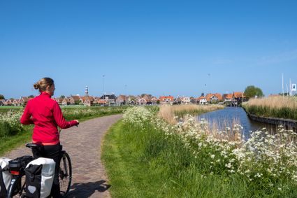 Vrouw met roze jasje fietst naar Hindeloopen