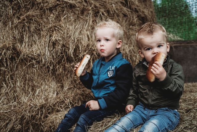 Kinderen eten een worstenbroodje op Beleefboerderij 't Zandeind