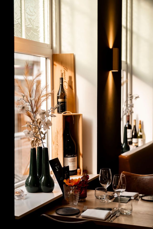 Sfeervol interieur van restaurant 3 Keuken & Bar in Oudewater met wijnflessen en gedekte tafel