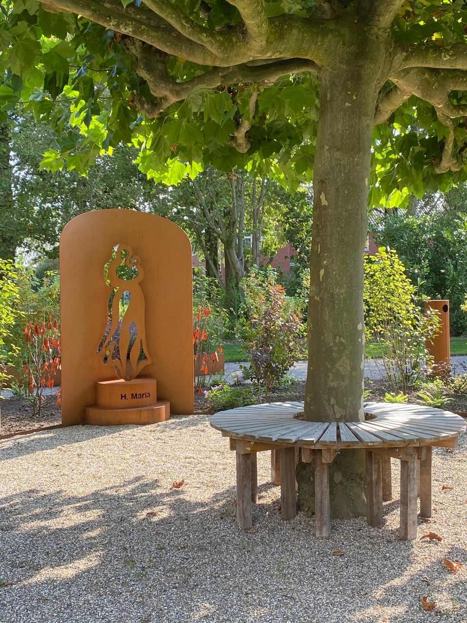 Kunstwerk in Inspiratietuin Cabauw met bankje in de schaduw van een bladerdek