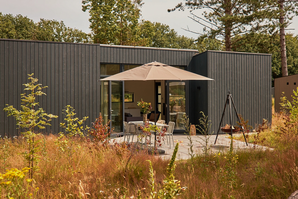 Een luxe vakantiehuisje met terras in een natuurrijke omgeving.