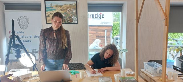 Margot Daleman en Jolle Fonk bestuderen metaaldetectorvondsten van amateurarcheologen.
