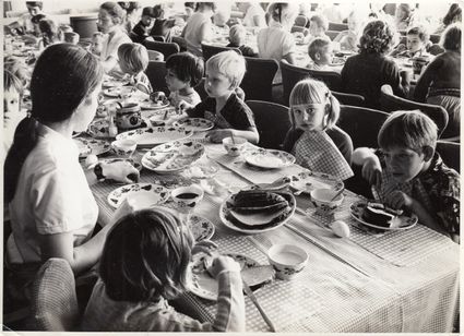 Zwart-wit foto van kinderen die zitten te eten aan een lange tafel in Kindertehuis Rustoord in Oisterwijk