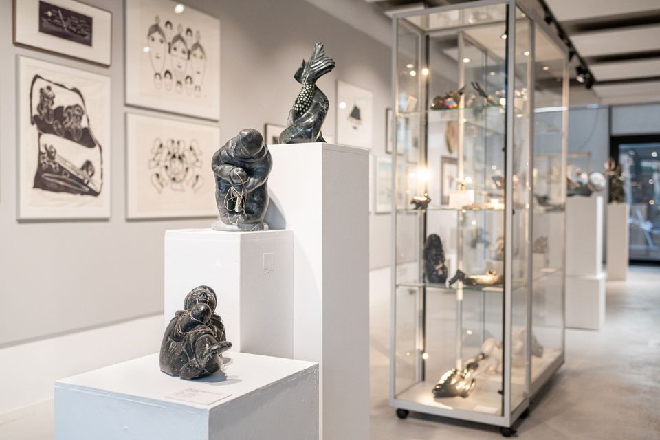 zaal met beeldjes, vitrines met kunst en kunstwerken aan de muur