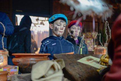 Twee kinderen als pieten, met pietenmuts en roetvegen, in de Stad van Sinterklaas