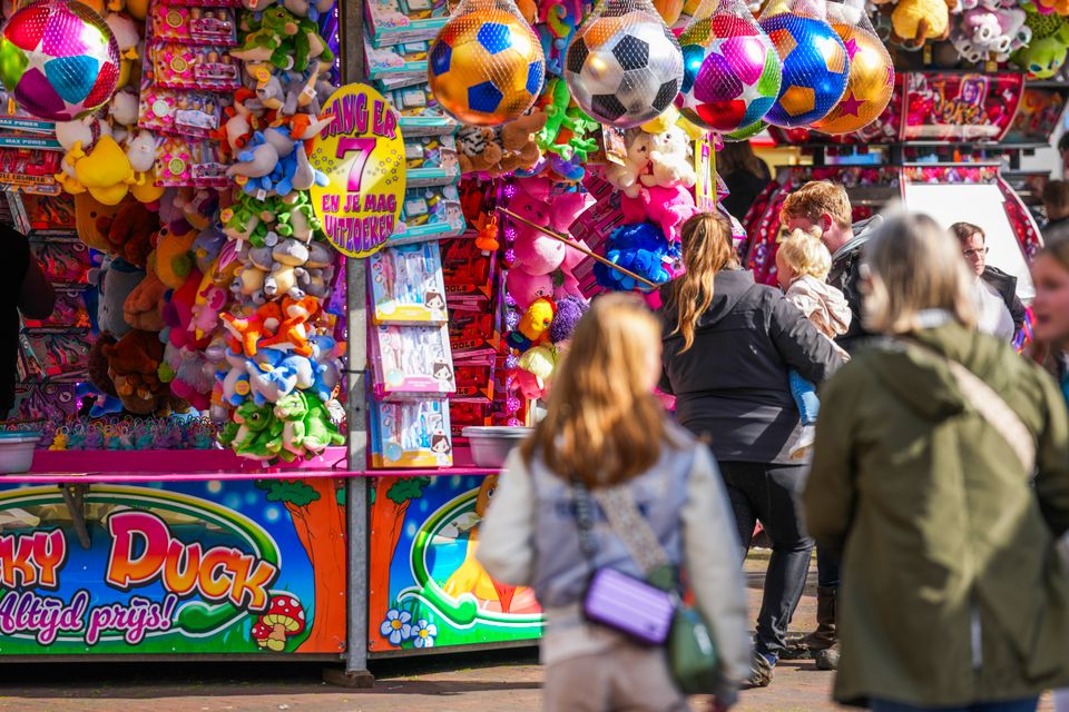 Een moeder en dochter lopen over de kleurrijke kermis van de Jouster Merke