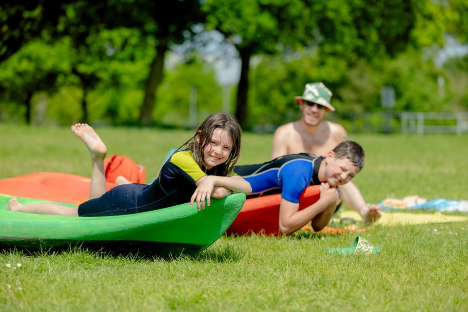 Kinderen die tijdens het zomerse weer op een supboard liggen.