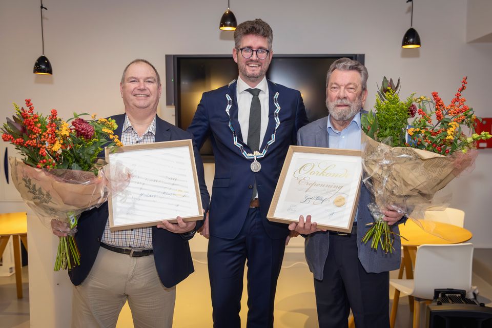Locoburgemeester Martijn Kroonen reikt de Gemeentelijke Erepenning uit aan Marcel van Raaij en Gert Rikhof als waardering voor hun twaalf jaar inzet en leiderschap binnen de Culturele Raad Maassluis.