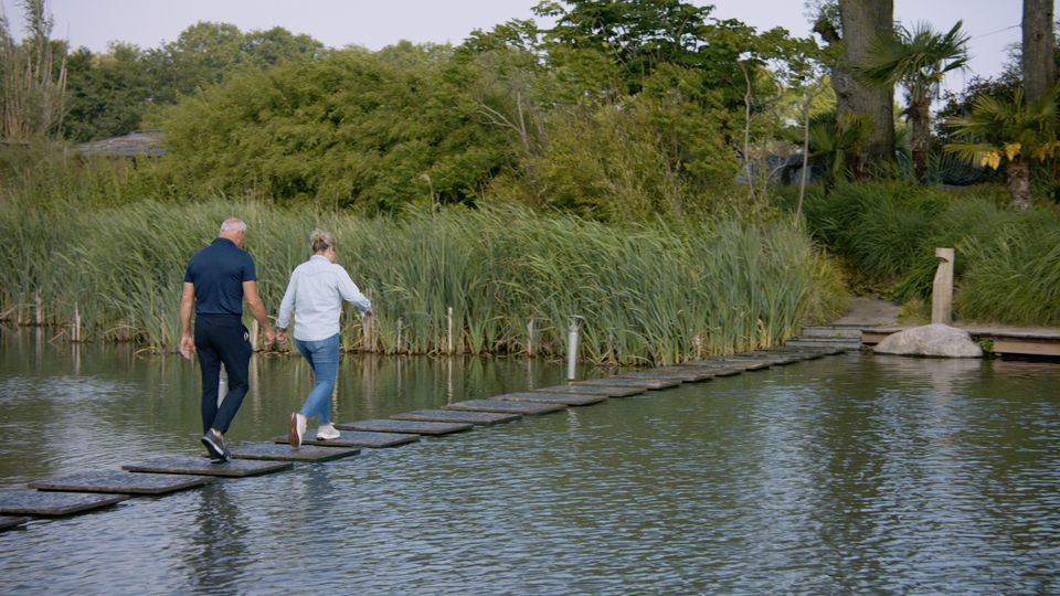 Een man en een vrouw lopen samen over een brug bij een fort.