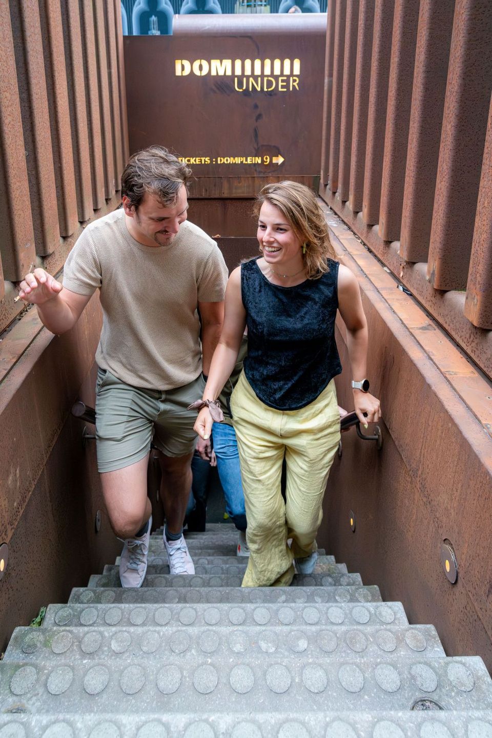 Bezoekers beklimmen de trappen van DOMunder op het Domplein.