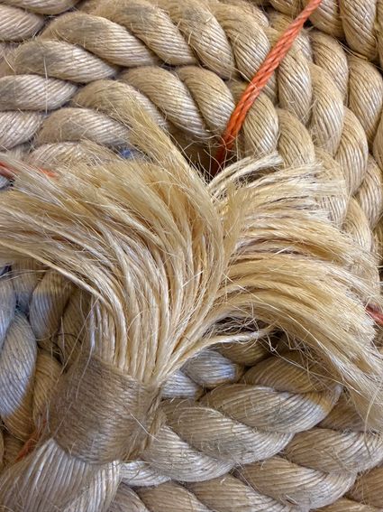 Detailfoto van touwvezels in het Touwmuseum De Oude Touwbaan, Oudewater, Groene Hart. Close-up van dik gedraaid natuurtouw met rafelige hennepvezels, ambachtelijke touwproductie en historisch touwslagersvak.