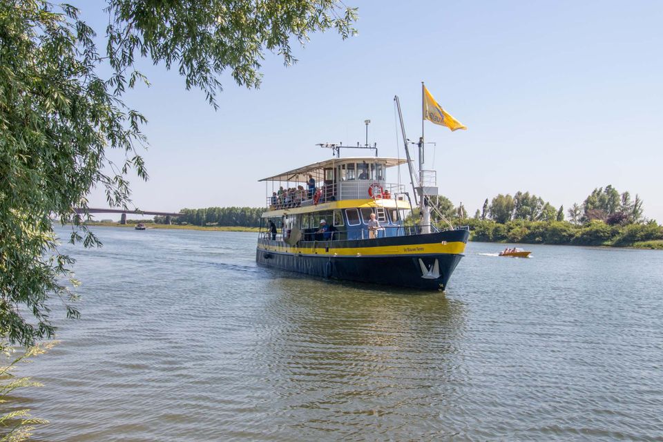 Passagoers verlaten na het aanleggen het schip voor een stadswandeling met gids door het oude stadje Rhenen.