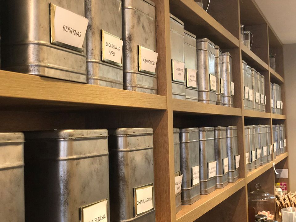 Thee-assortiment in metalen blikken in Bakkerij Versluis in Woerden, sfeervol detail van het interieur.