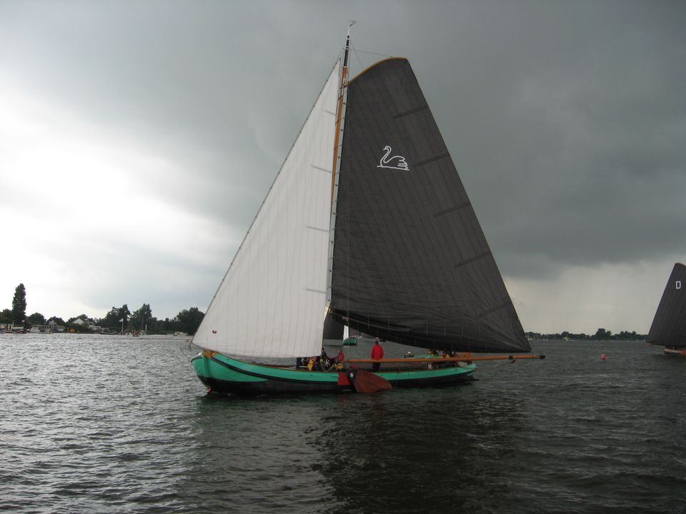 Een skûtsje 'De twee Gebroeders' Langweer vaart op het meer met donkere lucht op de achtergrond.