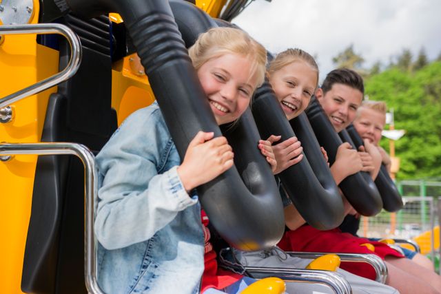 Vier kinderen genieten van een achtbaanrit in Attractiepark Drouwenerzand