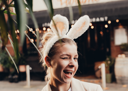 Restaurant Viviamo in Woerden, Groene Hart, vrolijke vrouw met konijnenoren tijdens paasviering voor paaslunch of paasdiner met sfeervolle horeca setting.