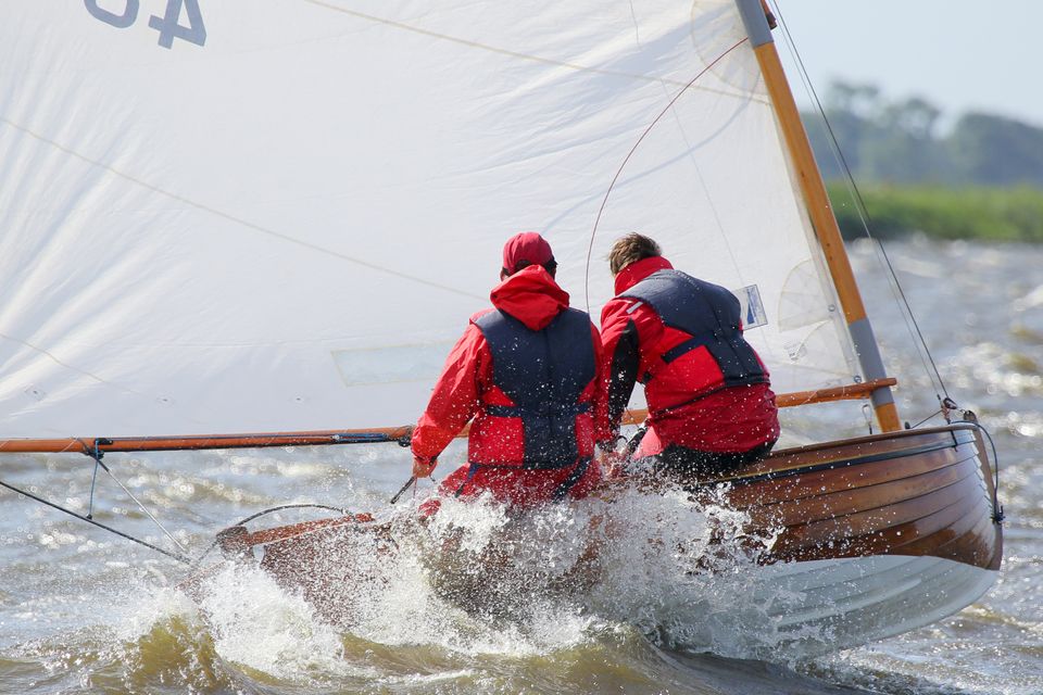 twee zeilers met een rode jas op een zeilbootje tijdens de sneekweek