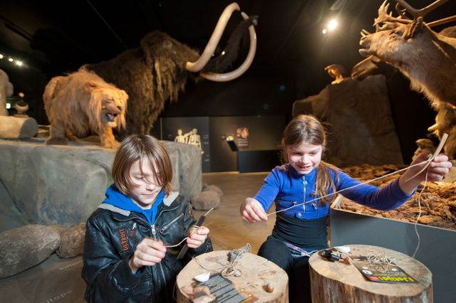 Twee kinderen maken iets van touw in het Natuurmuseum in Tilburg