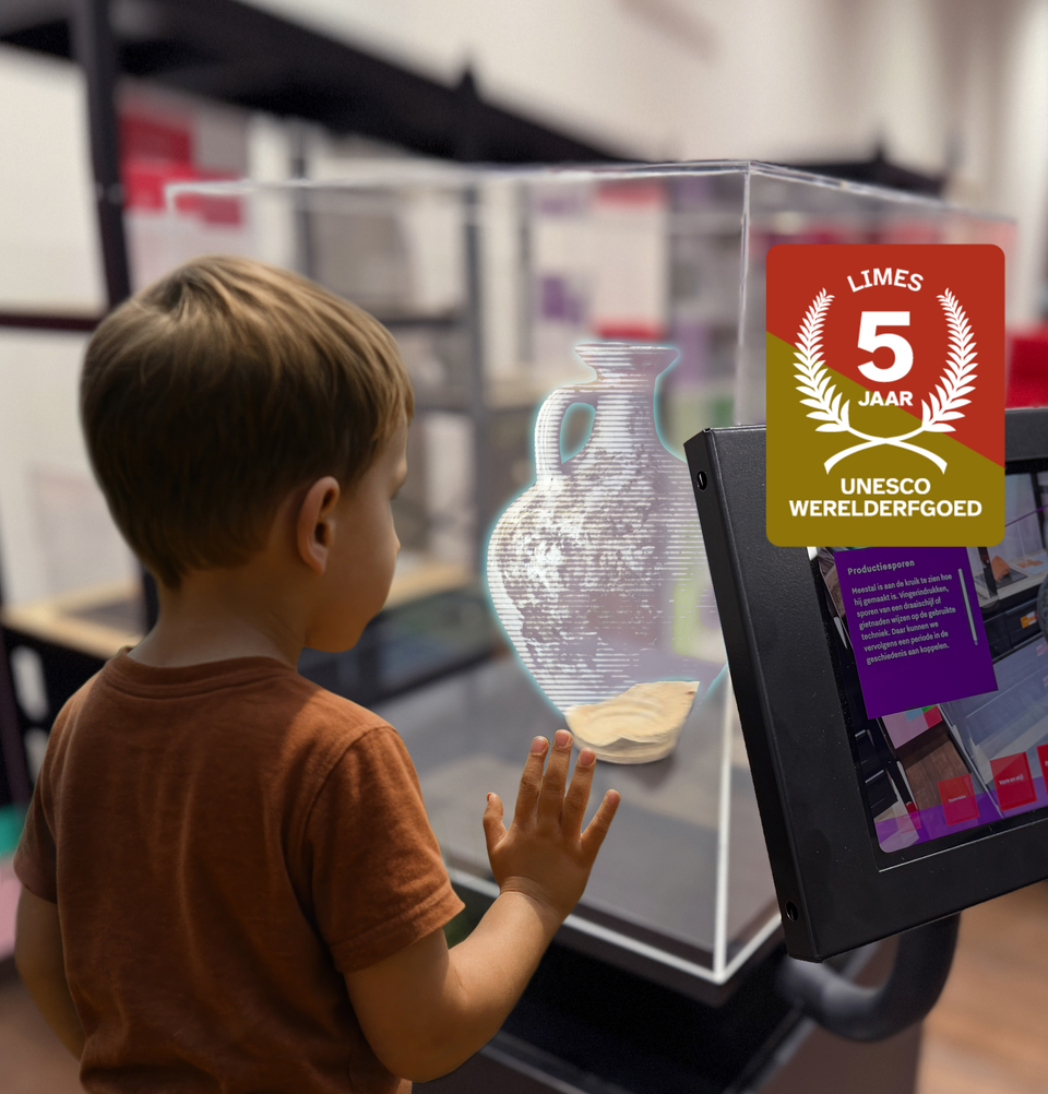 Tentoonstelling erfgoed over de Romeinse Limes in Woerden, Groene Hart. Kind bekijkt een digitale archeologiepresentatie met Romeinse vondsten tijdens het jubileum van 5 jaar UNESCO Werelderfgoed Neder-Germaanse Limes.