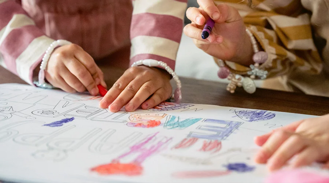 Kinderen kleuren een tekening met wasco krijtjes