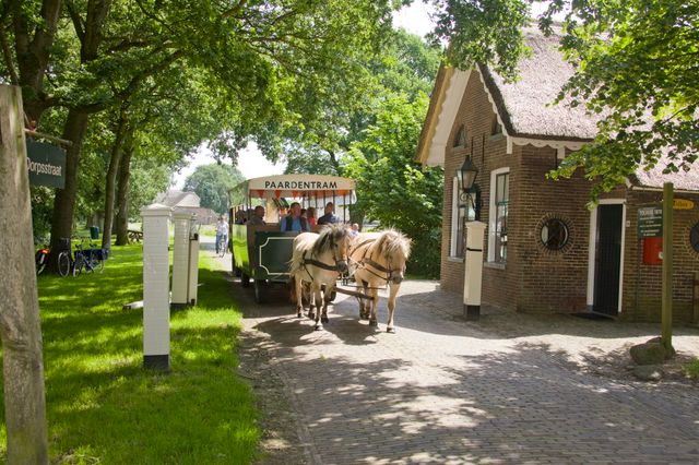 Een huifkar rijdt door monumentendorp Orvelte.