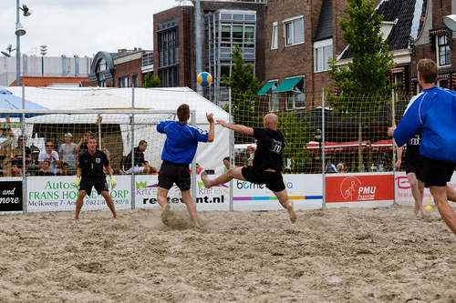 Mensen die aan het voetballen zijn op het strand
