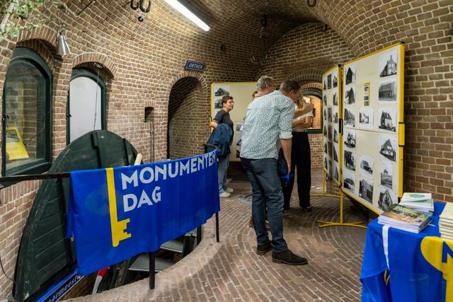 Bezoekers van Fort Orthen bekijken de fotorapportages