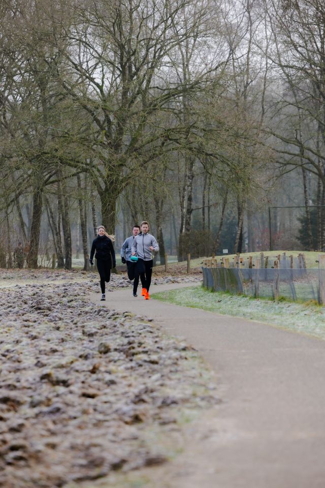 Twee mannen en een vrouw hardlopend in de winter