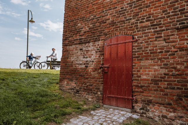 Detailfoto Gevangentoren Megen met fietsers op de achtergrond