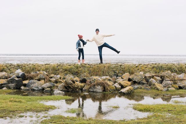 Man en meisje staan op een stenen wal aan het water