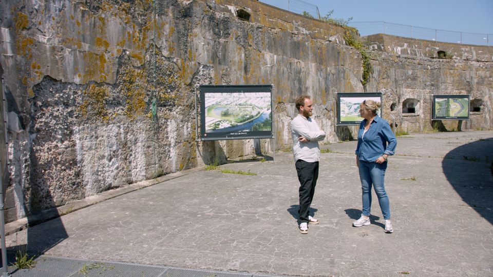 Een man en een vrouw staan samen in de droge fortgracht van Pampus.