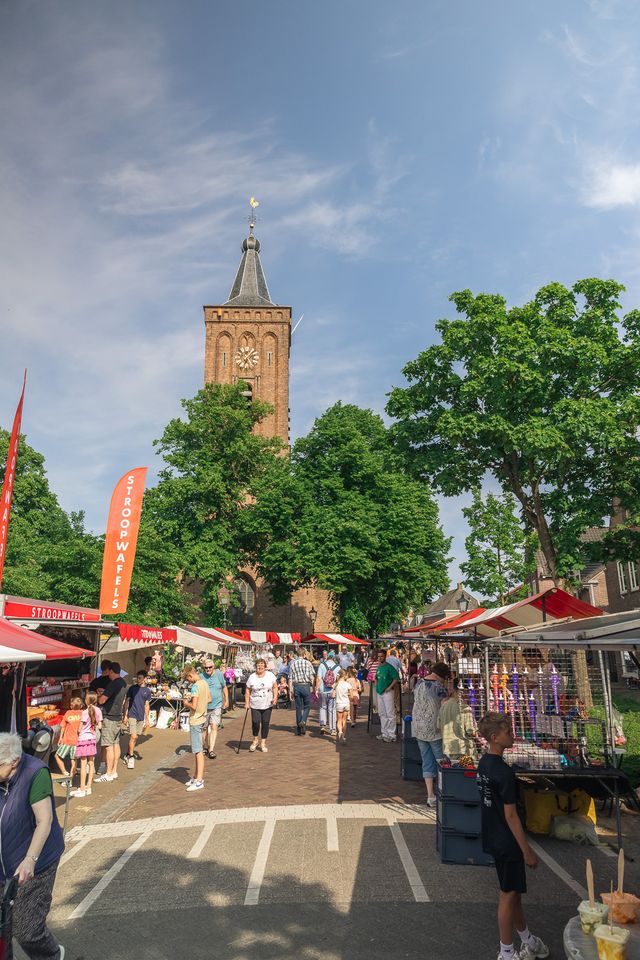 Markt met bezoekers en met een kerk op de achtergrond.