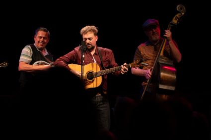 Poppodium Het Klooster Woerden, Woerden, Groene Hart, live muziekoptreden met drie muzikanten op het podium met gitaar, contrabas en mandoline tijdens een intiem concert.