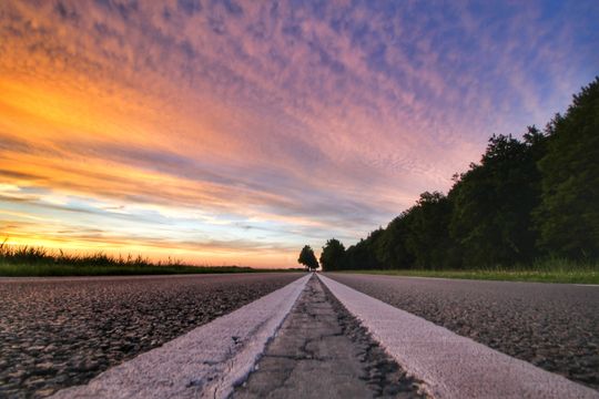 Close-up van de lijnen van een wegdek met op de achtergrond een strakke horizon in de Noordoostpolder.