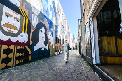 Dame loopt in de Kloksteeg in Delft