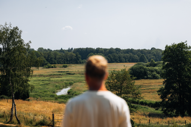 Een man kijkt uit over de kronkelende Schipborger Diep vanaf het uitzichtpunt op de Kymmelsberg.