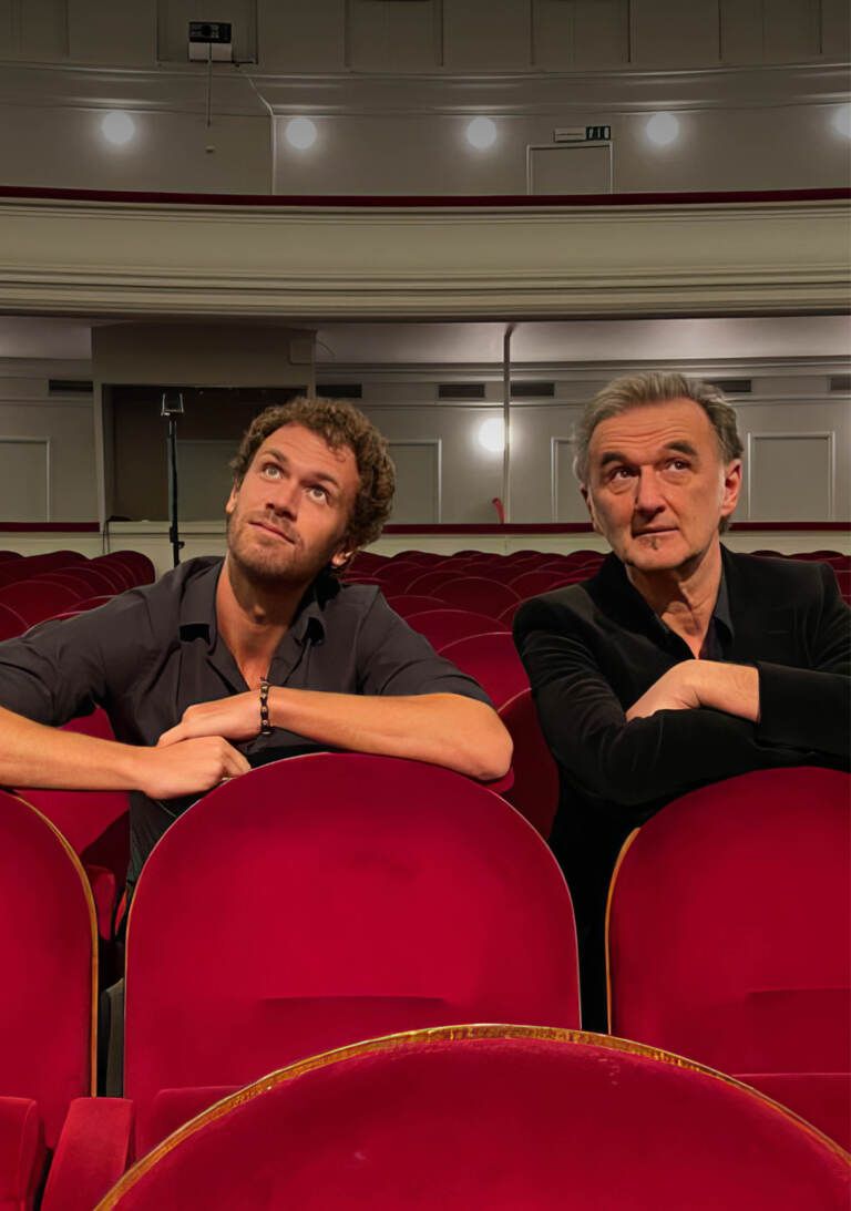 Twee mannen die in een theaterzaal zitten
