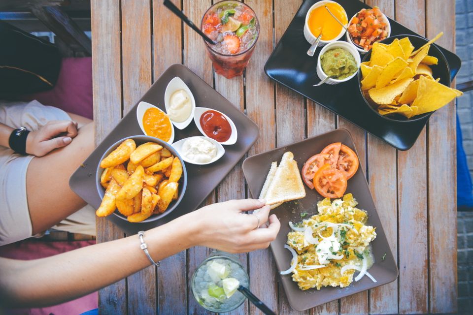 Tafel waar borden met eten op staan van bovenaf gefotografeerd.