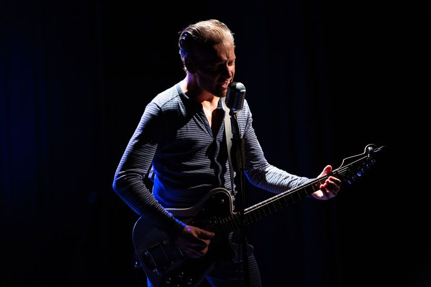 Man aan het optreden met een gitaar