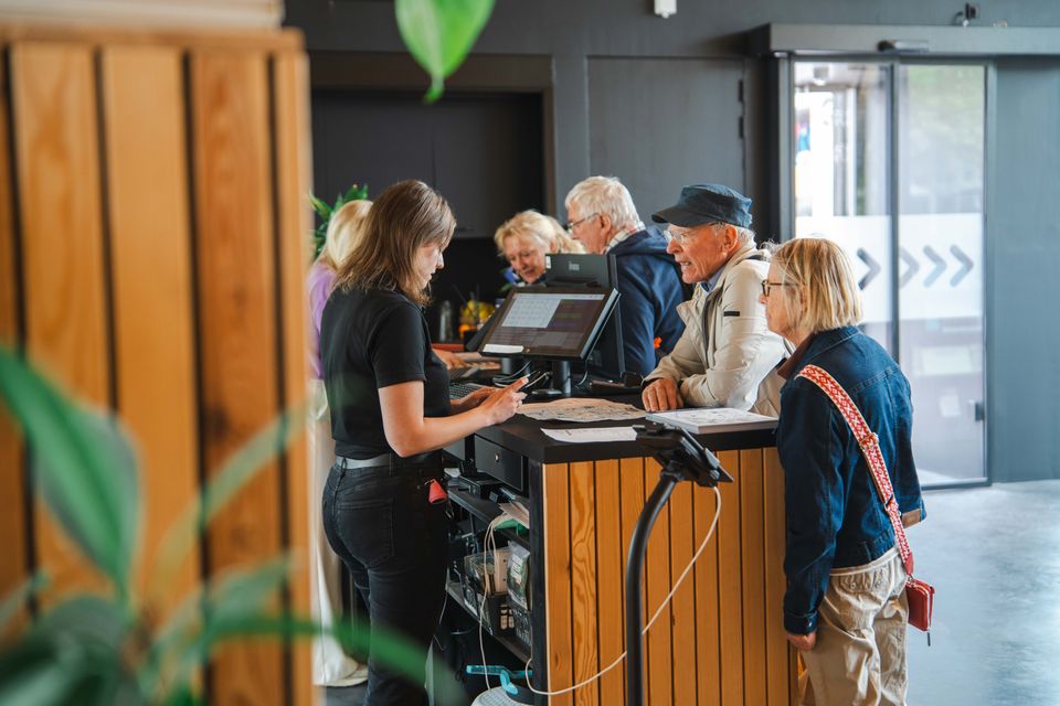Medewerkers in het Leeuwarden Visitor Center die toeristen helpen met het inwinnen van informatie over de stad
