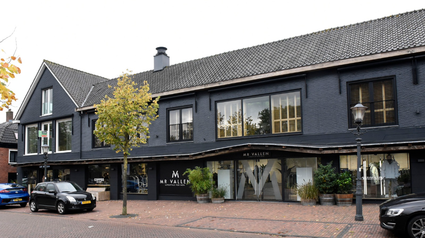Kledingwinkel Vallen Mode Harmelen, provincie Utrecht, Groene Hart, moderne herenmodezaak met donkere gevel, etalages en entree aan de Dorpsstraat in het dorpscentrum.