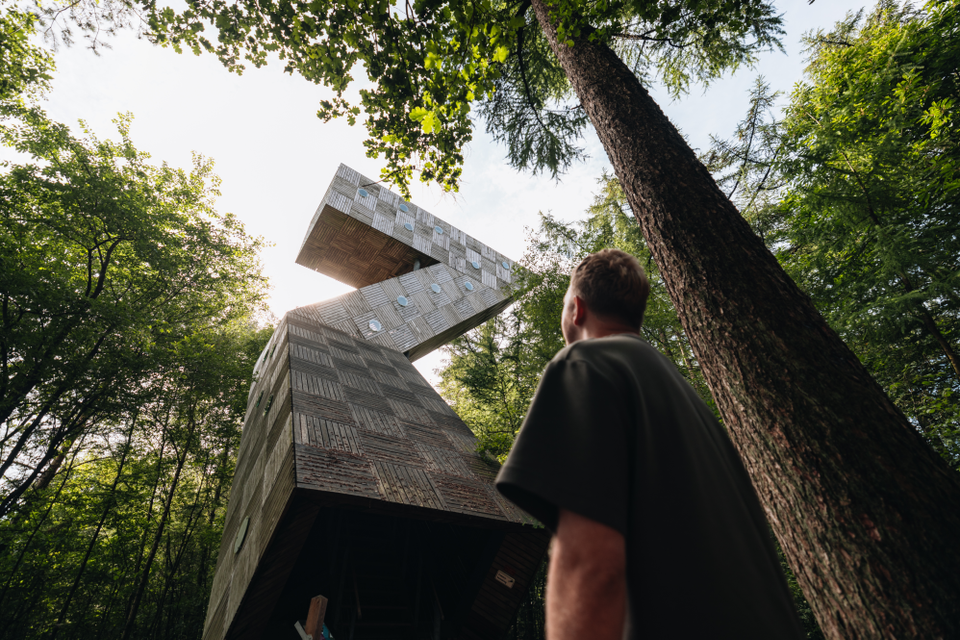 Ein Mann blickt vom Boden auf den Endpunkt des Aussichtsturms De Zeven, der tatsächlich die Form einer Sieben hat.