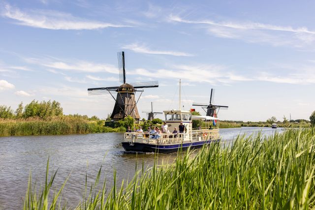 Rondvaart Kinderdijk, Alblasserdam, Zuid-Holland, Groene Hart, rondvaartboot vaart langs historische windmolens en rietkragen op UNESCO Werelderfgoed Kinderdijk tijdens een toeristische boottocht in het Groene Hart.