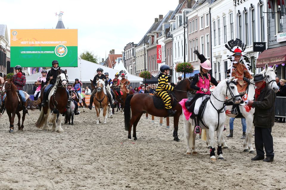 De Paardenmarkt Vianen, de straten liggen vol zand en op het zand lopen paarden.