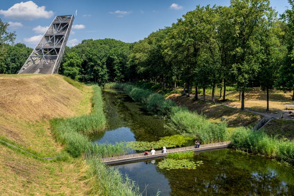 Schuine uitkijktoren op een dijkje met gracht eromheen