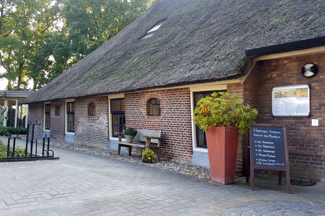 Boerderij met rieten dak waarin een hotel restaurant gevestigd is.