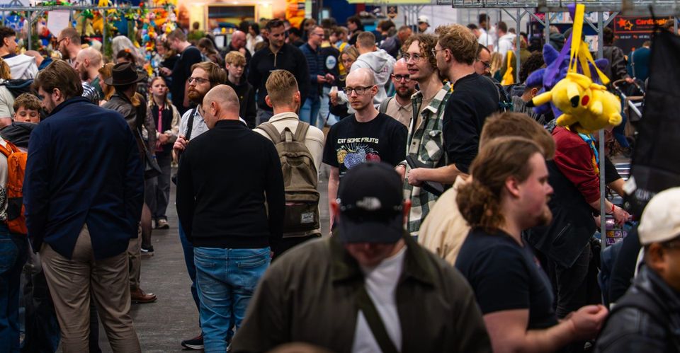 Bezoekers, verzamelaars en standhouders in de beurshal van Con La Posta.