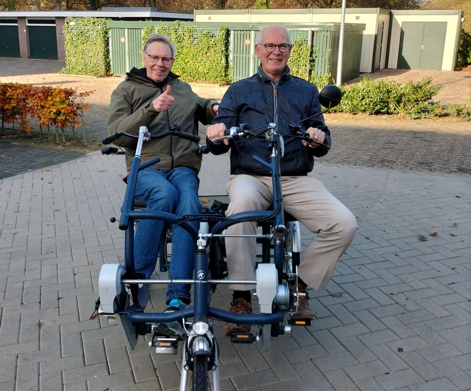 Twee vrijwilligers van Logeerhuis Bredius maken een rit op een duofiets in Woerden, als onderdeel van een toegankelijk en sociaal uitje voor gasten.